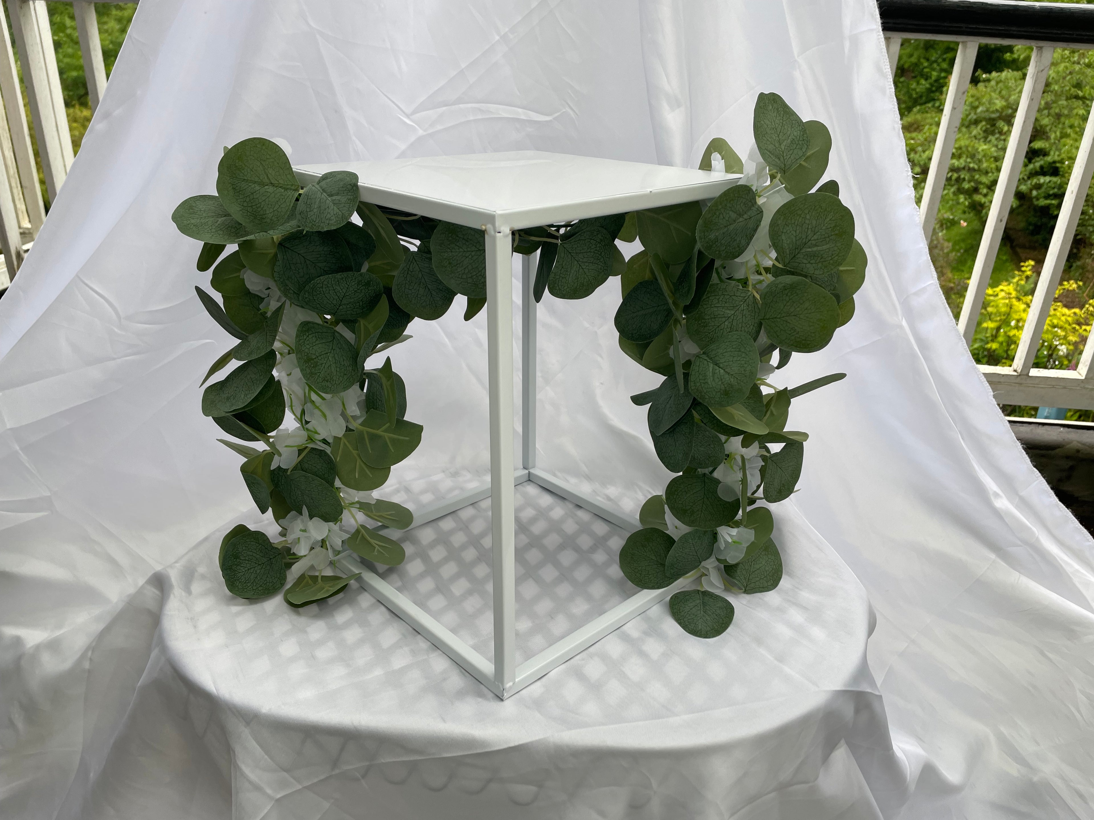 White Metal Square Wedding Stand with Eucalyptus and delicate white flowers