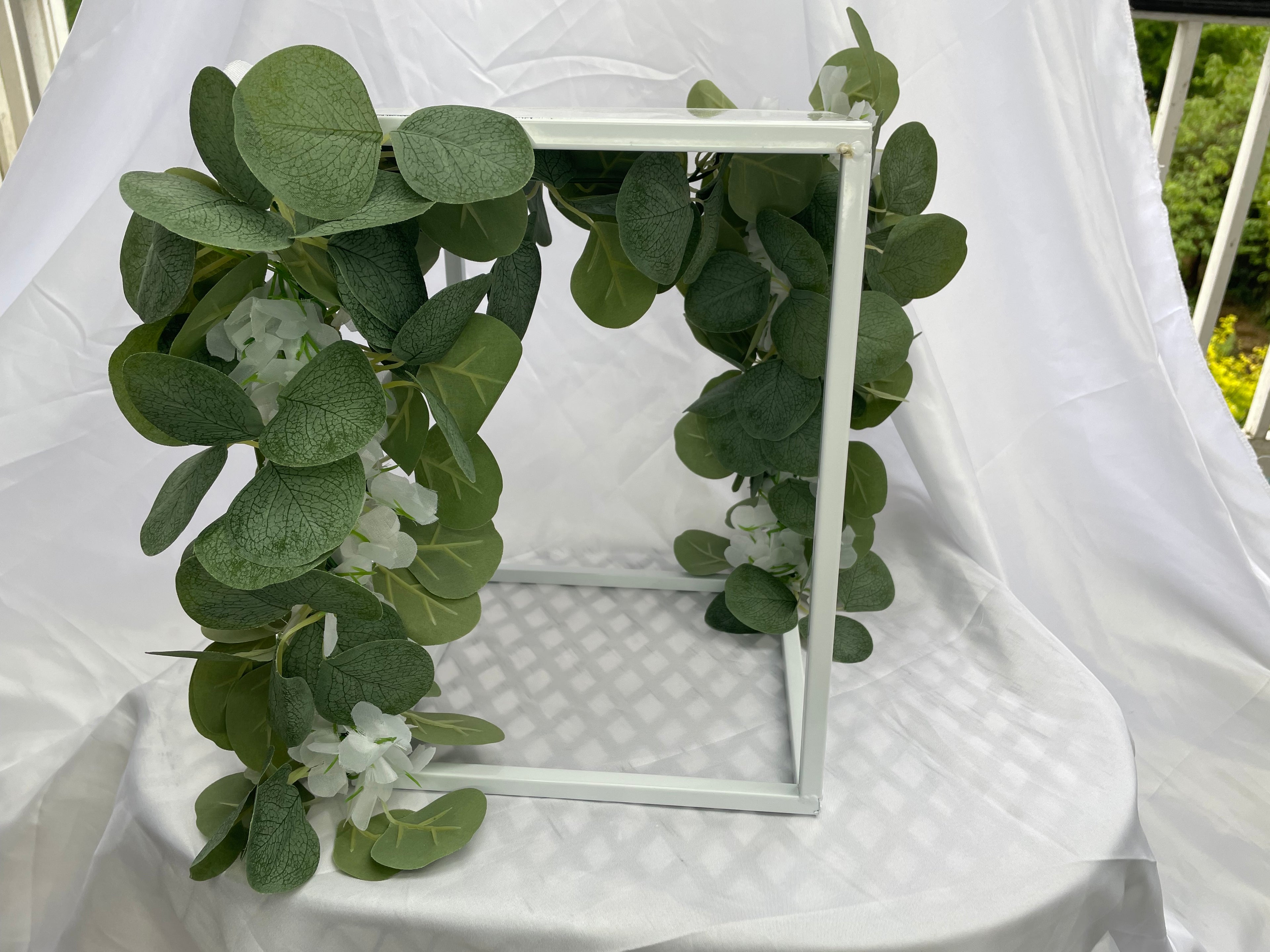 White Metal Square Wedding Stand with Eucalyptus and delicate white flowers