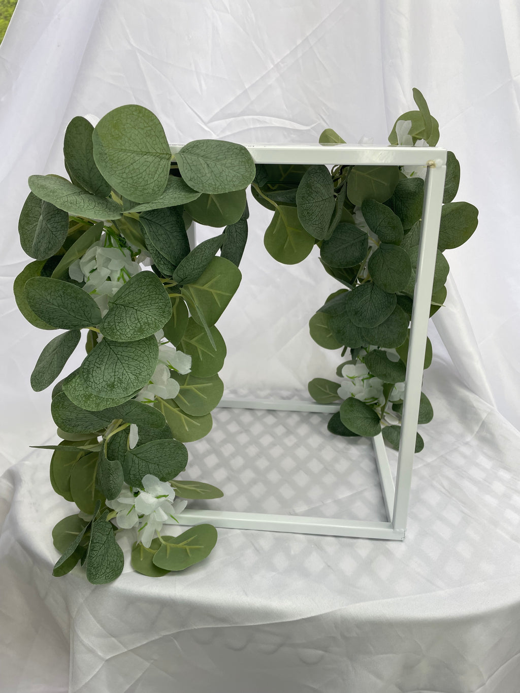 White Metal Square Wedding Stand with Eucalyptus and delicate white flowers