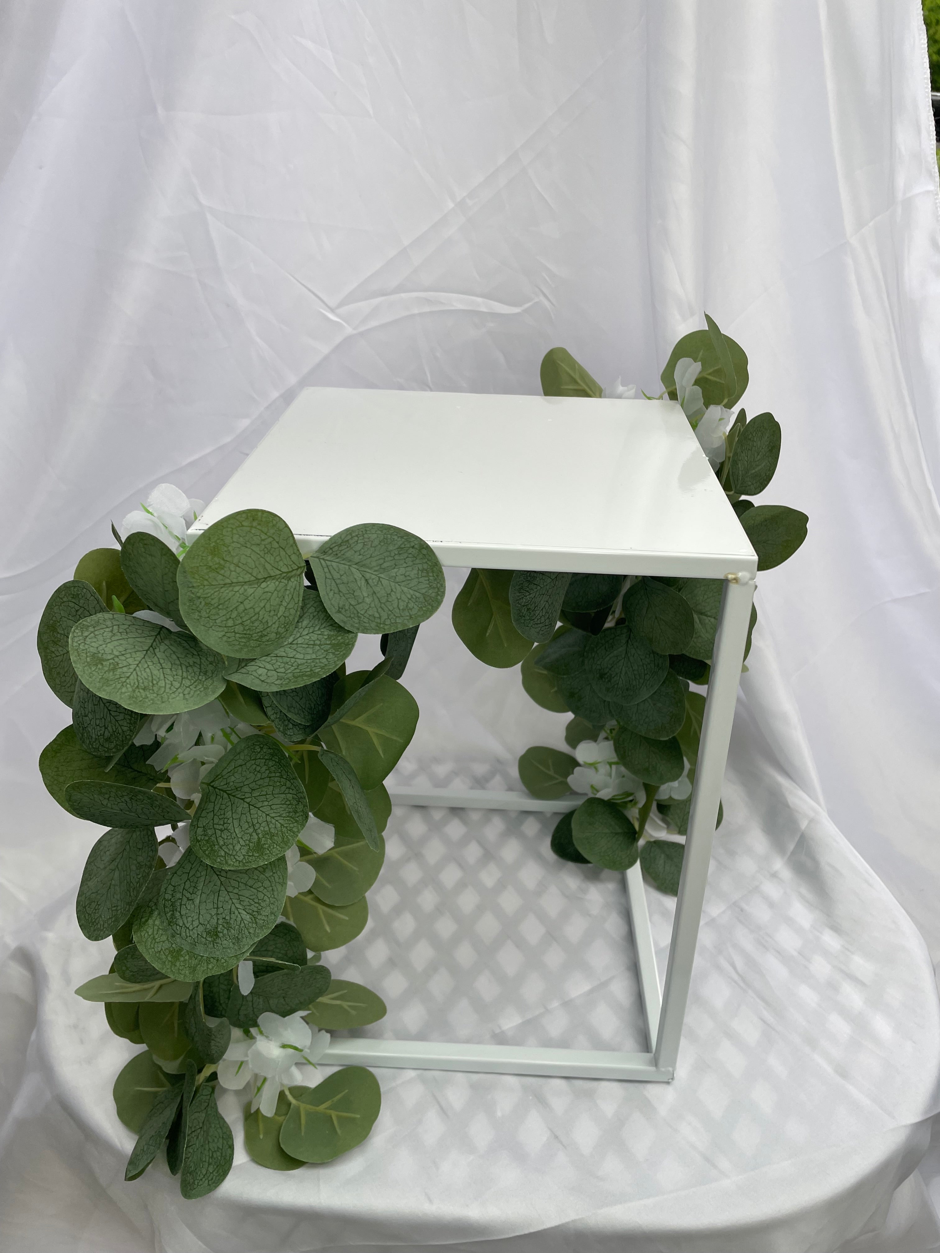 White Metal Square Wedding Stand with Eucalyptus and delicate white flowers