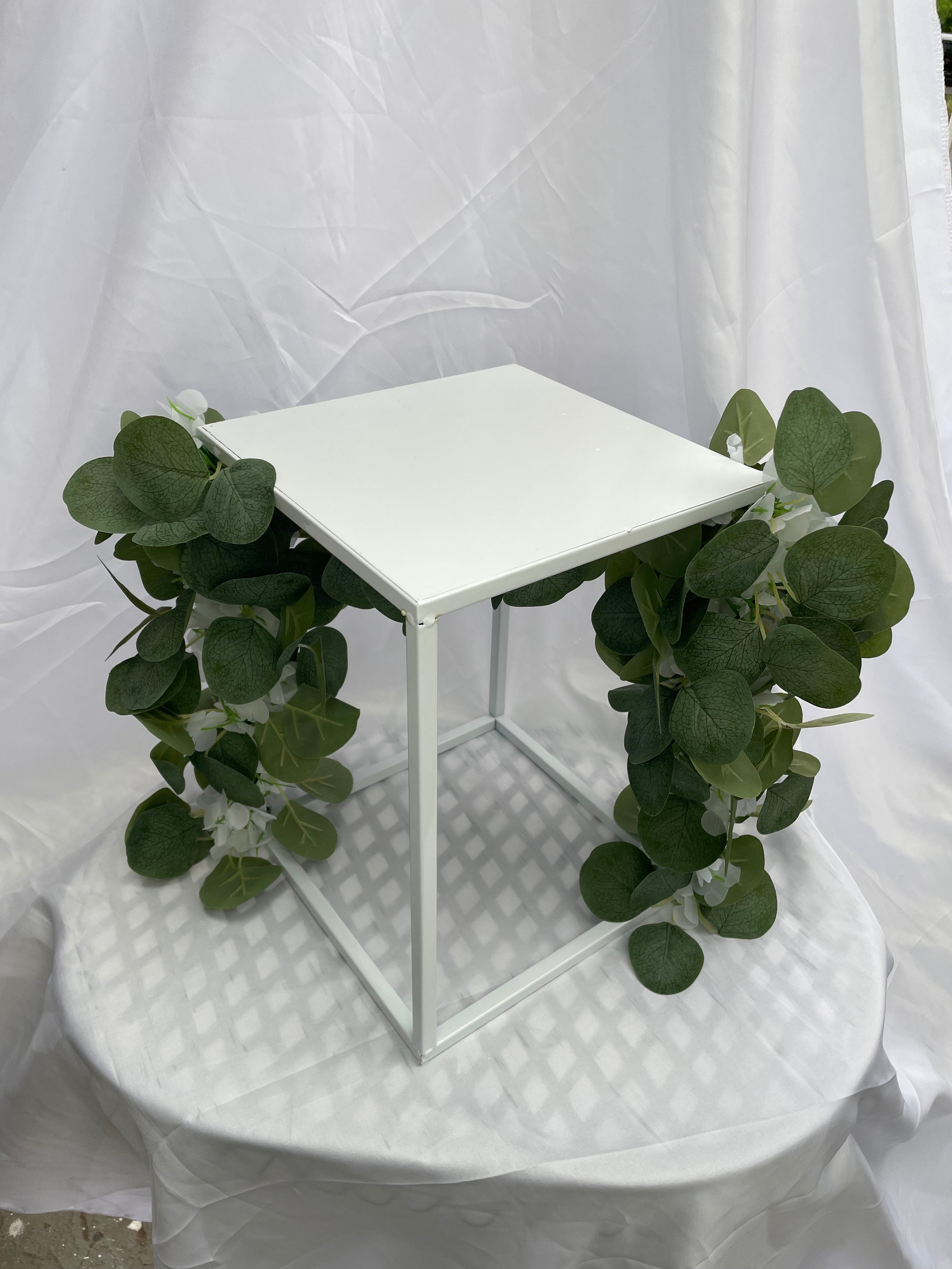 White Metal Square Wedding Stand with Eucalyptus and delicate white flowers