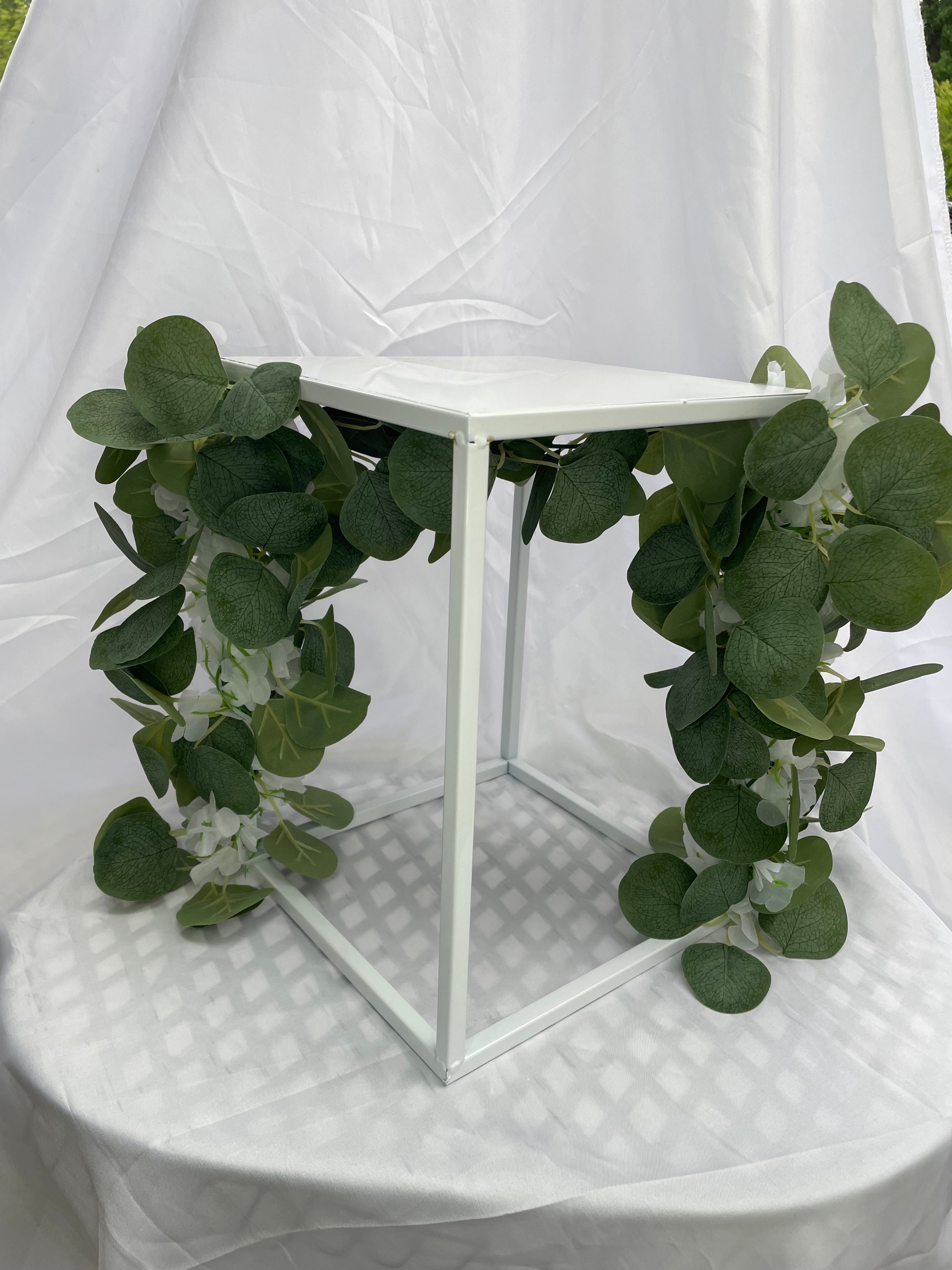 White Metal Square Wedding Stand with Eucalyptus and delicate white flowers